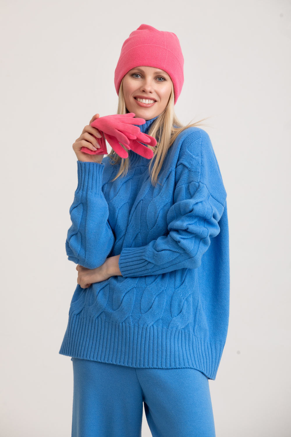 Pulover albastru Florentinodelure, model torsadat, cu mănuși și căciulă roz.