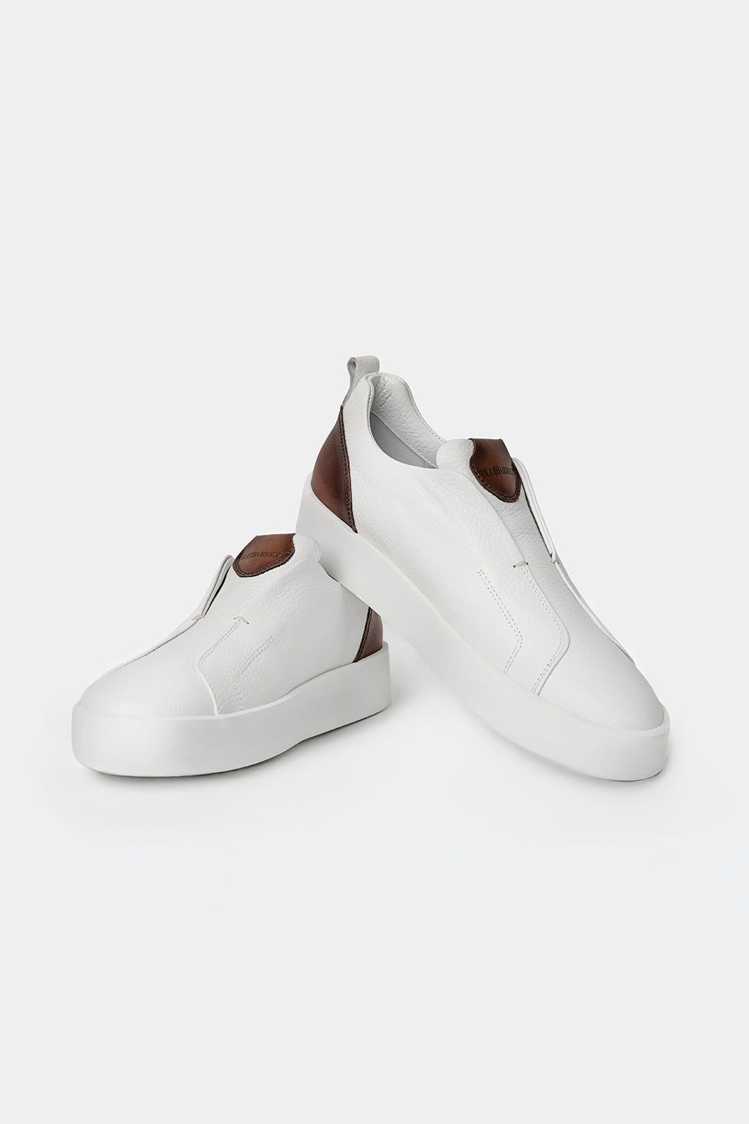 Sneakers albi Florentinodelure din piele cu detalii maro și talpă din cauciuc.
