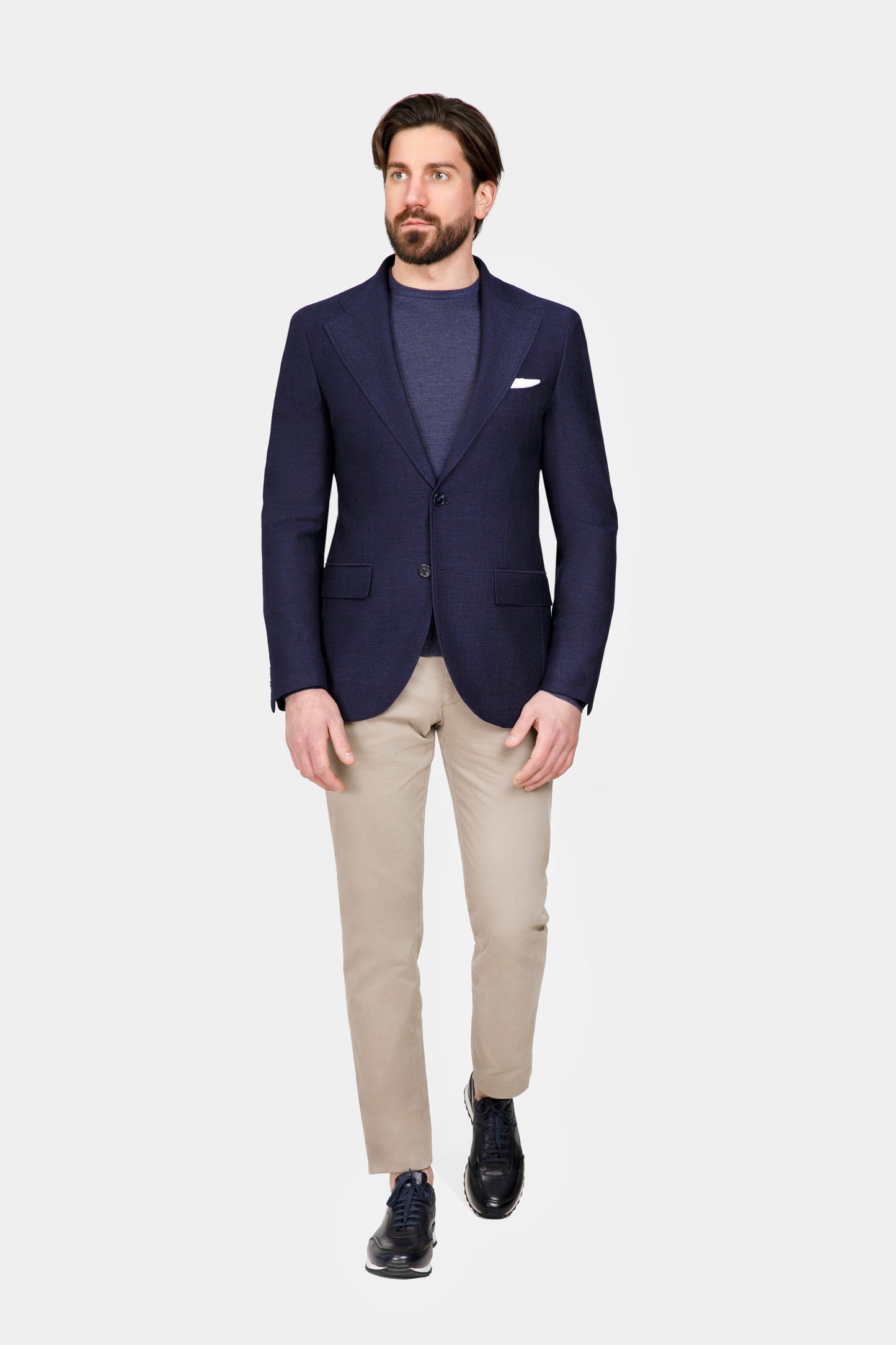 Sacou Phoenix Herringbone Navy Florentinodelure, lână, două nasturi, buzunar piept, purtat cu pantaloni bej.